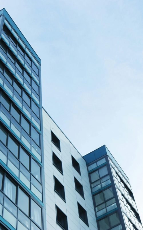 pexels-photo-323705-323705 Low-angle view of a modern glass skyscraper against a clear sky in Poole, UK.